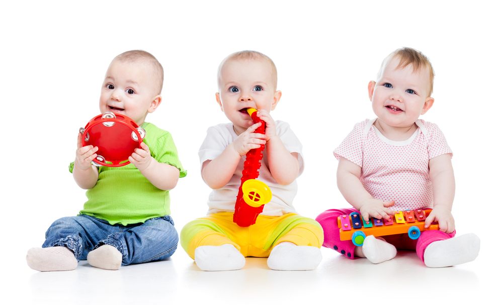 Bebés jugando con instrumetos muscales:xilófono, trompeta y pandereta