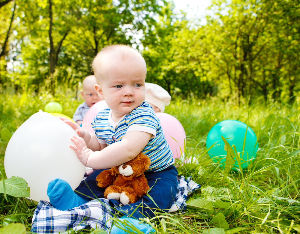 Bebés jugando en el campo con globos